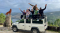 defender with people sitting on the rooftop of the car